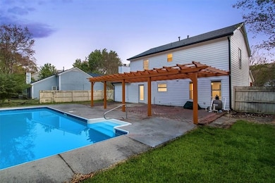 Back of property at dusk with fence, a fenced in p
