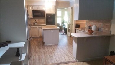 The bright kitchen reveals granite counters, spaci