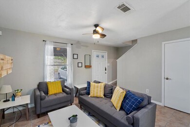 Living area with light tile patterned floors and ceiling fan