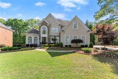 Traditional home with stucco siding and a front ya