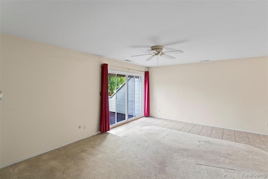 Tiled empty room featuring carpet floors and ceiling fan