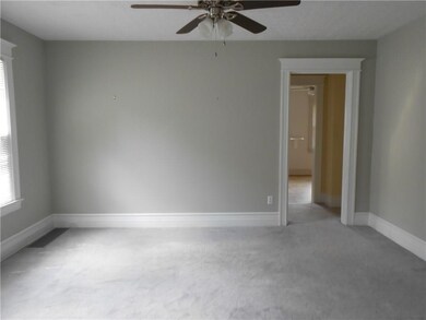 The formal dining room has a ceiling fan and wall-