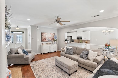 Living room with a chandelier, a ceiling fan, rece