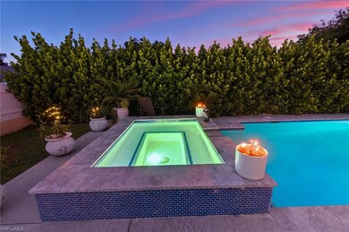 Pool at dusk with an outdoor pool, an in-ground hot tub, and a patio area