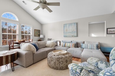 Living room featuring ceiling fan, high vaulted ce