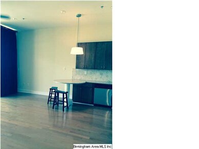 A sun filled kitchen and living space with hardwoo