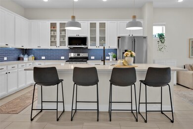 Elegant pendant lights hang above the island, addi