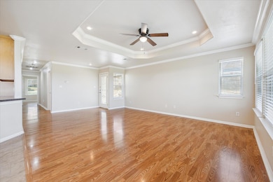 Unfurnished living room featuring a raised ceilin