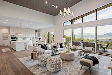 Living area featuring a mountain view, dark wood-style floors, recessed lighting, a towering ceiling, and a chandelier