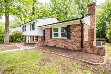 Split level home featuring a chimney, brick siding
