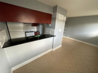 Kitchen with white appliances, baseboards, dark c