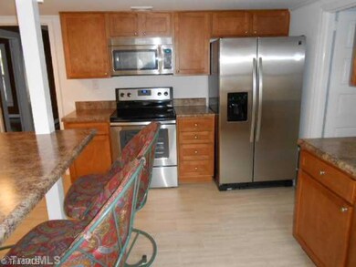 Kitchen. Completely remodeled kitchen with new everything. Cabinets, tops appliances, eating bar etc. Open with lots of light! Exits to Porch.