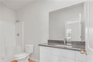 Full bath with a shower, vanity, and wood finished floors