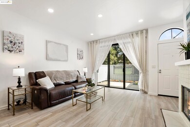 Living area with a tiled fireplace, recessed lighting, and light wood finished floors