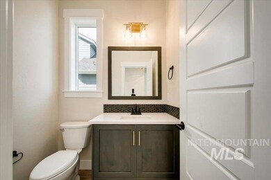 Half bathroom featuring vanity and tasteful backsplash