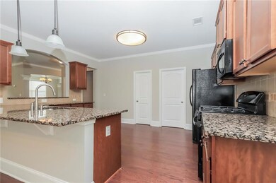 Kitchen featuring black appliances, tasteful backsplash, ornamental molding, brown cabinetry, and stone counters