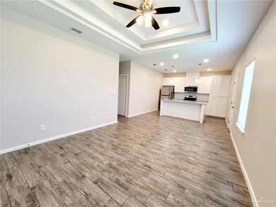 Unfurnished living room with ceiling fan, light wood-style floors, a raised ceiling, and recessed lighting