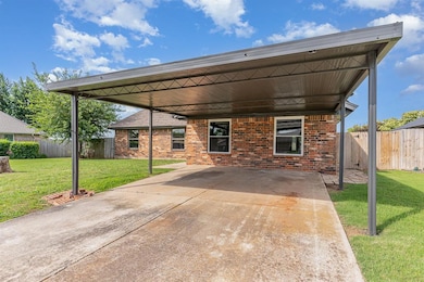 View of patio featuring a carport and concrete driveway