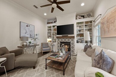 Living room featuring visible vents, a tiled firep