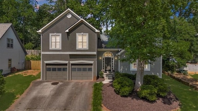 View of front of property with stucco siding, an attached garage, and driveway