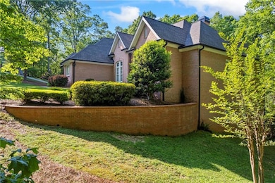 View of side of property with brick siding, a yard