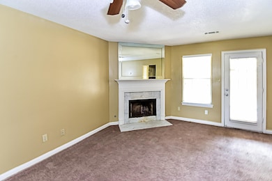 Unfurnished living room with carpet, ceiling fan, a textured ceiling, and a premium fireplace