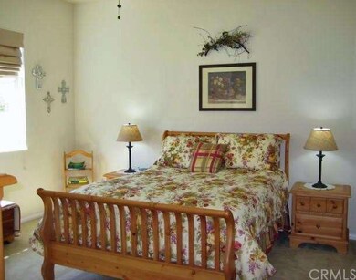 A spacious master suite adorned with Roman shades and ceiling fan.  The home is in soft neutral colors giving it a gentle, comfortable feel.