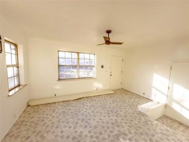 Carpeted spare room featuring a healthy amount of sunlight and ceiling fan