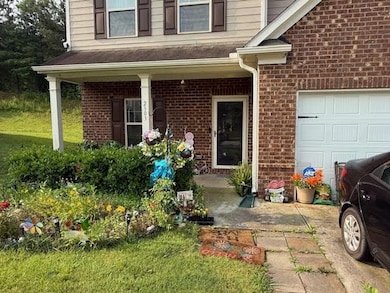 Property entrance with brick siding and a garage