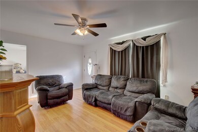 Living room with ceiling fan and light hardwood /