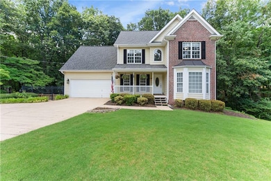 Traditional home with covered porch, concrete driveway, and an attached garage