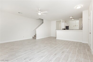 Unfurnished living room featuring ceiling fan, sta