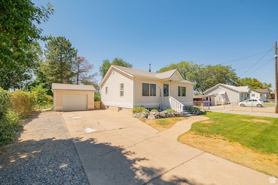View of front of house featuring concrete driveway and an outbuilding