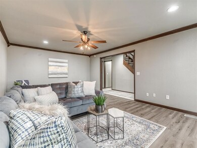 Living room featuring crown molding, ceiling fan, and light hardwood / wood-style flooring