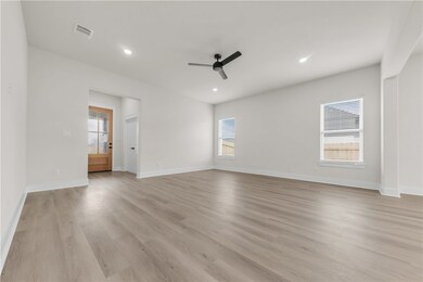 Empty room with ceiling fan, light wood-style floo