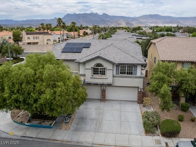 View of front of home featuring solar panels, a garage, concrete driveway, stucco siding, and a mountain view