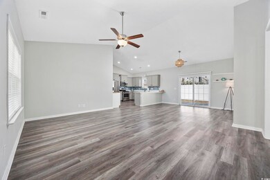 Unfurnished living room featuring ceiling fan, dar