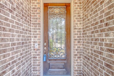 A landscaped pathway leads to the leaded glass door that allows for natural light to illuminate the front foyer.