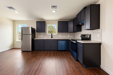 Modern and chic. Dark
cabinets, wooden floored  k