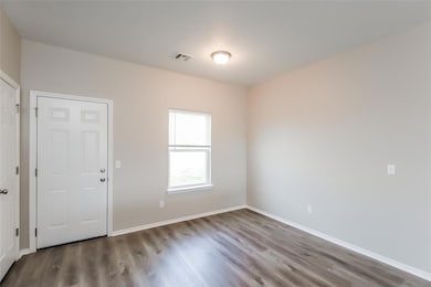 Unfurnished room featuring hardwood / wood-style f