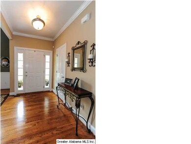 Foyer ~ hardwood floors, crown molding. Door to ri