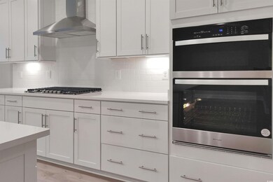 Kitchen with backsplash, light hardwood / wood-sty