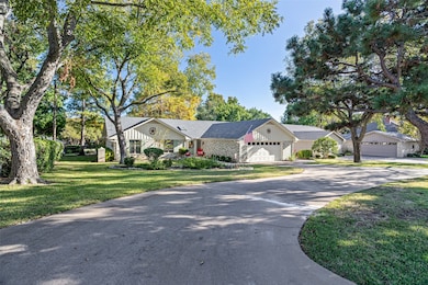 Ranch-style home featuring a front yard, board and batten siding, driveway, a shingled roof, and brick siding