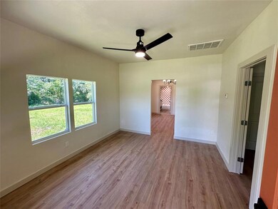 Empty room featuring a ceiling fan, a chandelier, wood finished floors, and baseboards