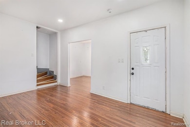 Foyer entrance with wood finished floors and recessed lighting