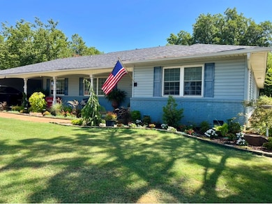 View of front of property with brick siding, a front yard, and a shingled roof