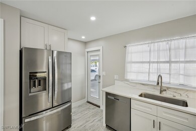 Kitchen featuring white cabinetry, appliances with stainless steel finishes, light countertops, and a sink