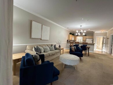 Carpeted living room with crown molding and a chan