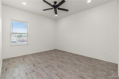Spare room with wood finished floors, a ceiling fan, recessed lighting, and baseboards