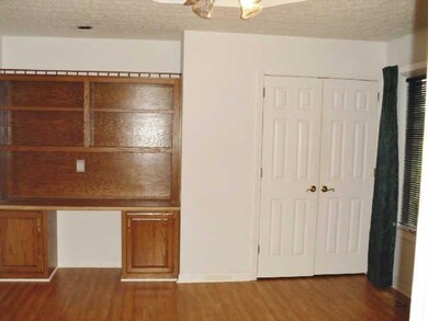 Bedroom with built-in bookcase and desk. Recessed ceiling light/fan.  Door that leads to full hall bath.